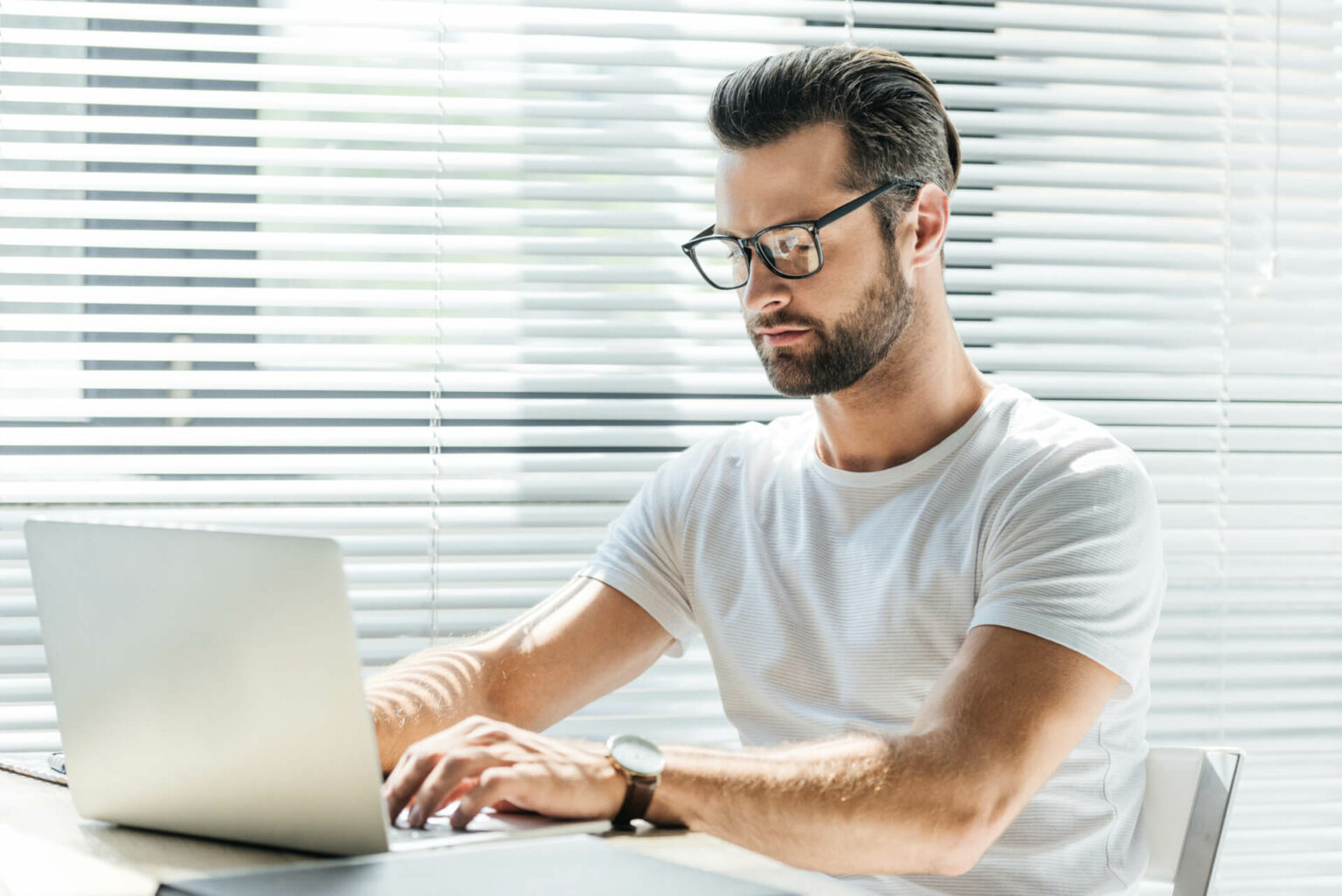 Mann erstellt am Laptop Briefings für Textaufträge